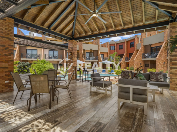 Porta al Sole Unit 11 covered community area next to the pool featuring a high wooden roof, ceiling fan, and various outdoor seating arrangements.