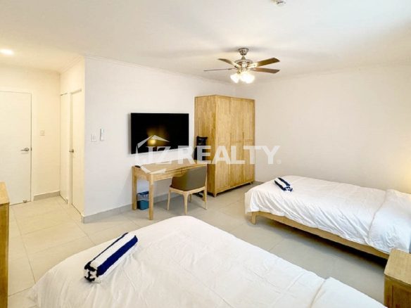 Bedroom with two single beds, a wardrobe, and a TV/desk area.