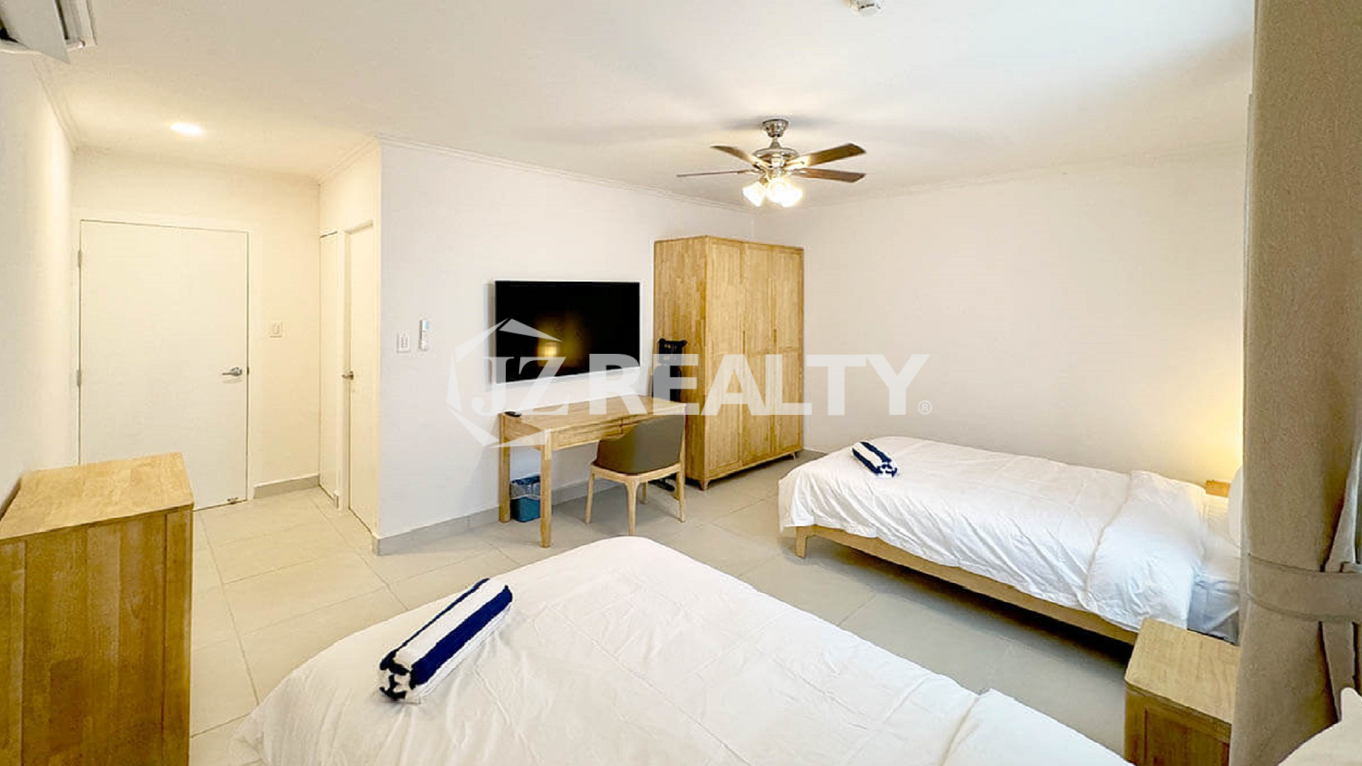 Bedroom with two single beds, a wardrobe, and a TV/desk area.