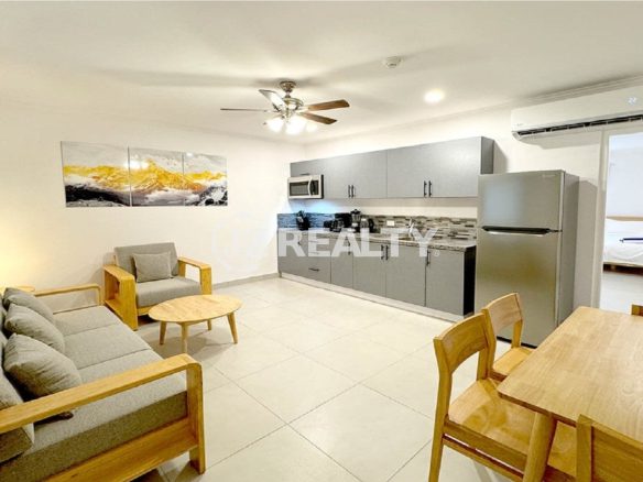 Wide view of the open-plan kitchen, living, and dining area.