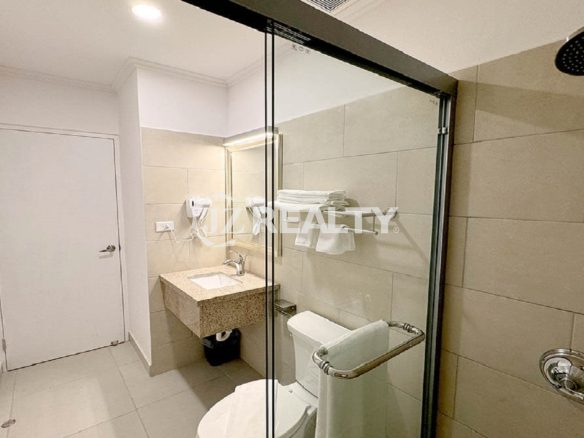 Luxury apartment bathroom with glass shower and modern fixtures.