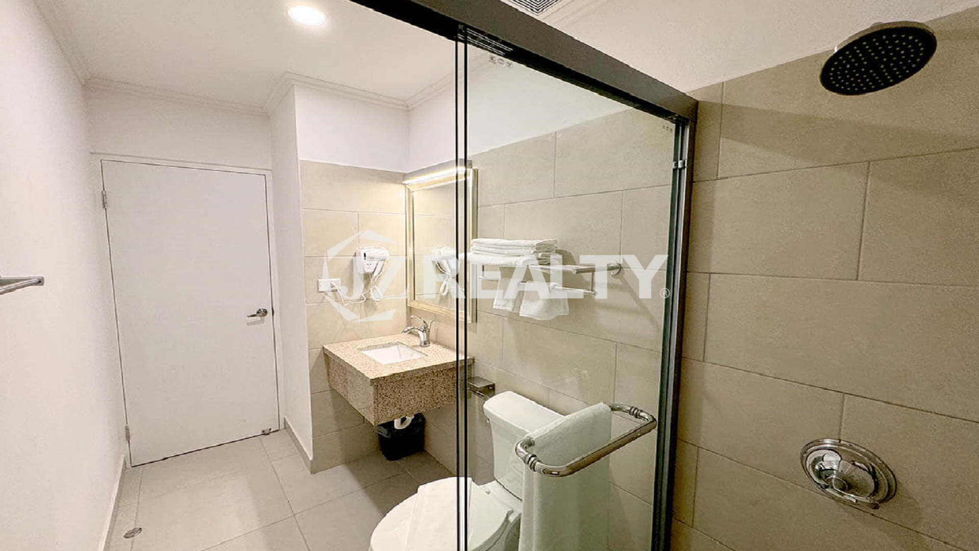 Luxury apartment bathroom with glass shower and modern fixtures.