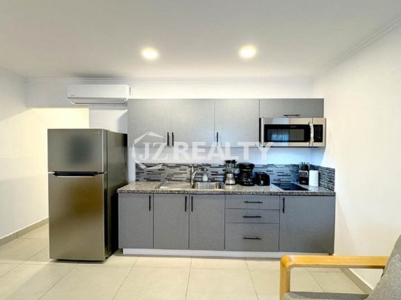Modern apartment kitchen with stainless steel appliances.