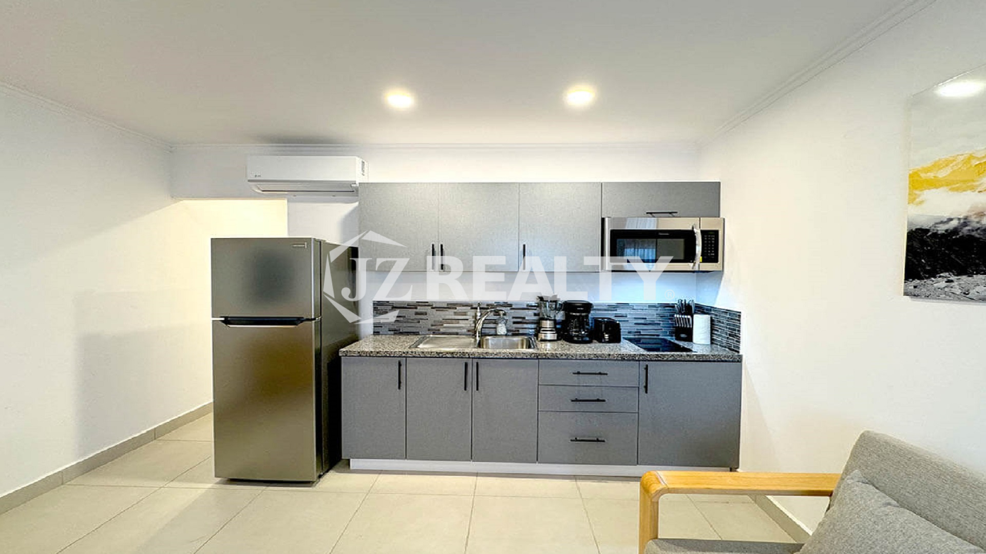Modern apartment kitchen with stainless steel appliances.
