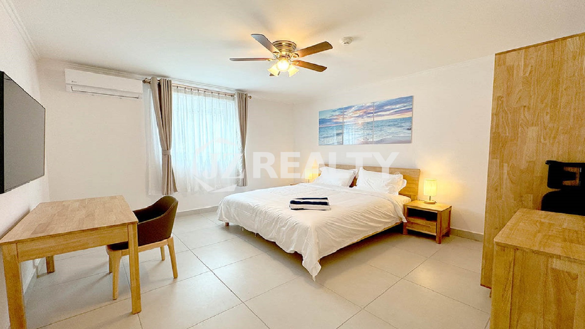 Bedroom with a king bed, air conditioner, and bright window.