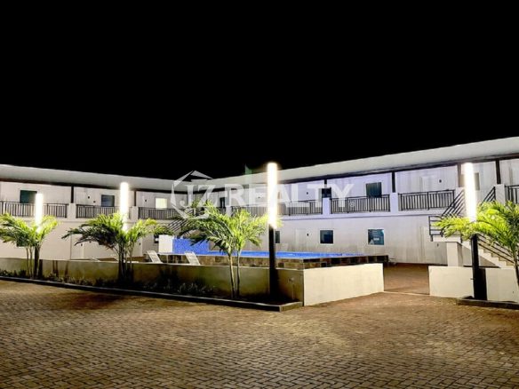 Night exterior view of the property with lighting and landscaping.