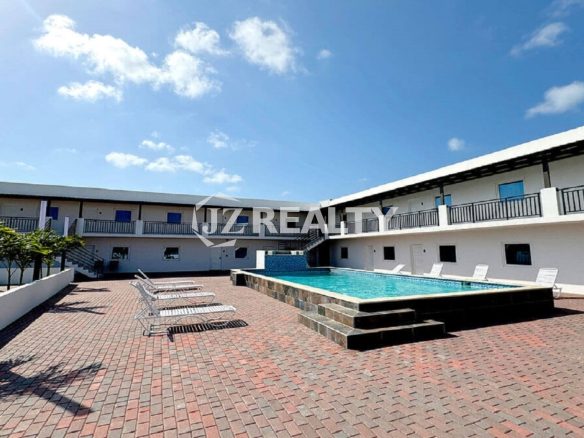 Daytime exterior view of apartment complex courtyard and pool.