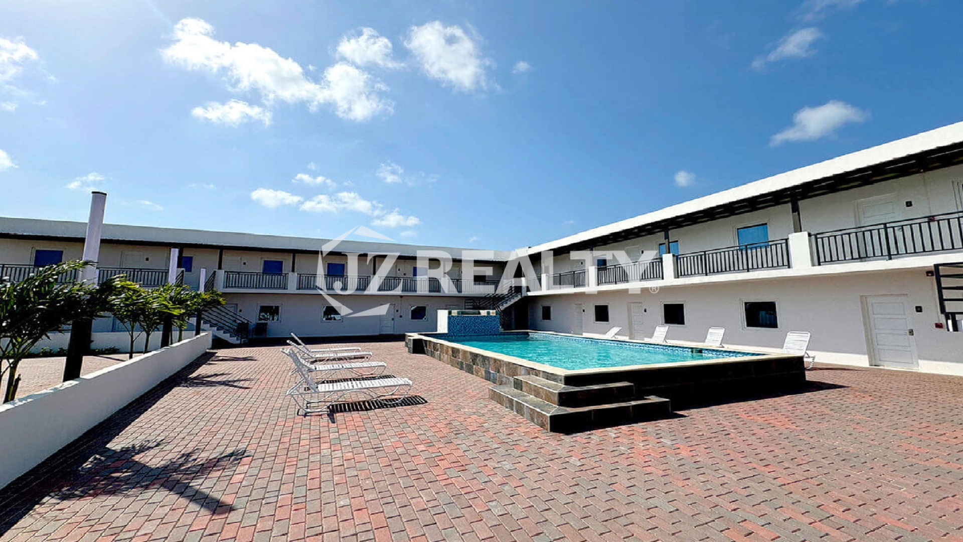 Daytime exterior view of apartment complex courtyard and pool.