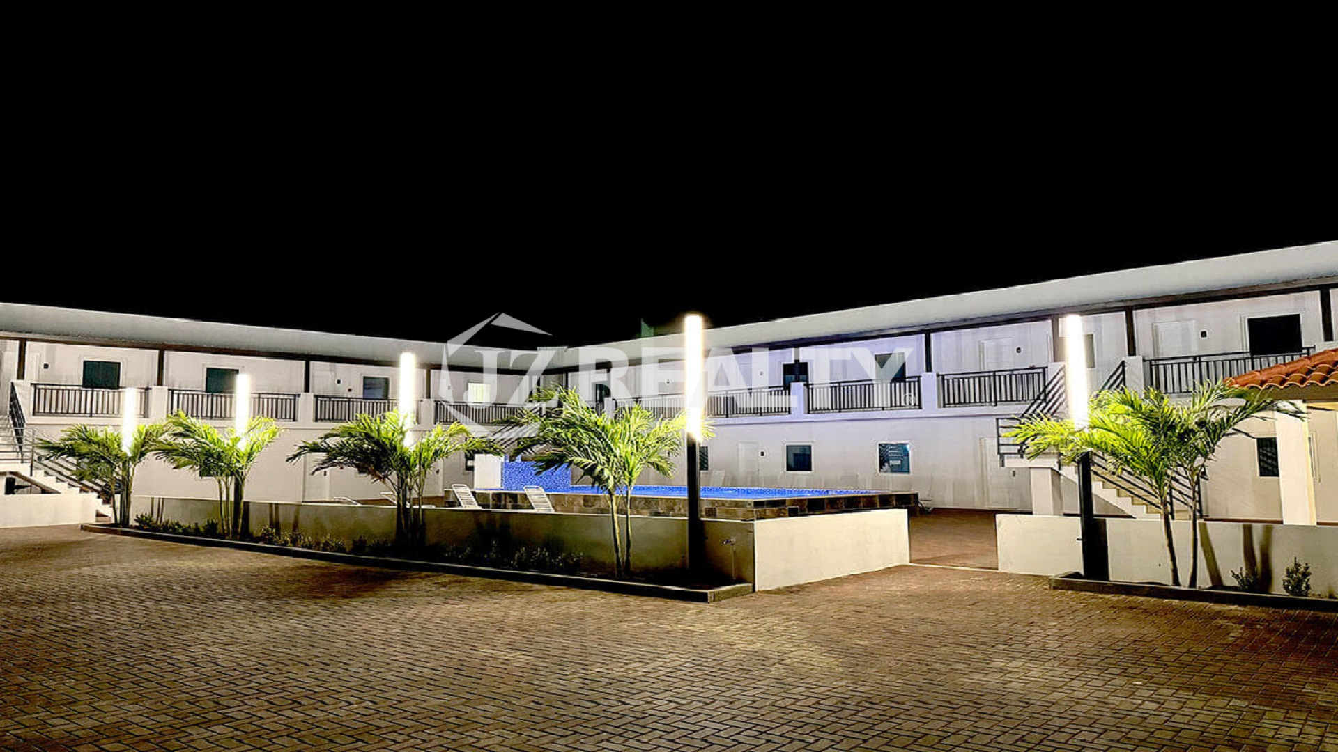 Night exterior view of the property with lighting and landscaping.