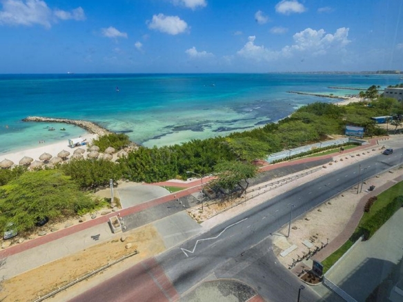 Aerial view near Penthouse PHA at The Reef Residences showing road and beach in Eagle Beach Aruba