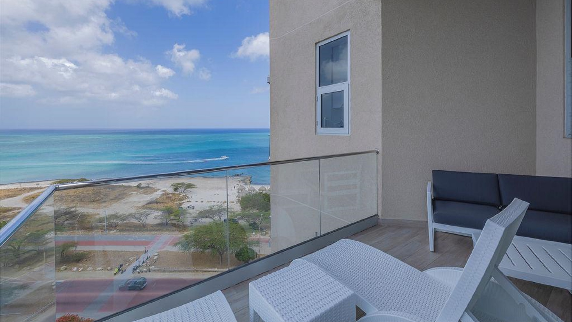 Balcony of Penthouse PHA at The Reef Residences with corner seating and ocean view in Eagle Beach Aruba