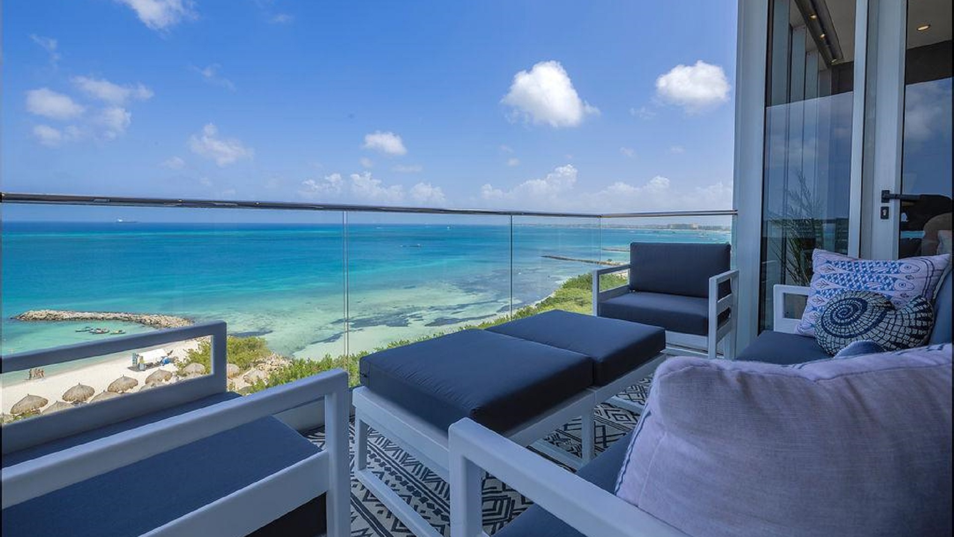 Balcony seating area of Penthouse PHA at The Reef Residences with side ocean view in Eagle Beach Aruba