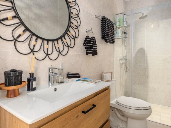 Bathroom in Penthouse PHA at The Reef Residences with decorative mirror and glass shower in Eagle Beach Aruba