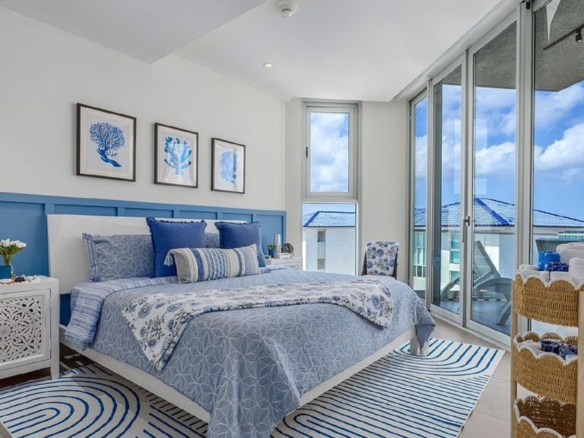 Bedroom in Penthouse PHA at The Reef Residences with balcony access and blue decor in Eagle Beach Aruba