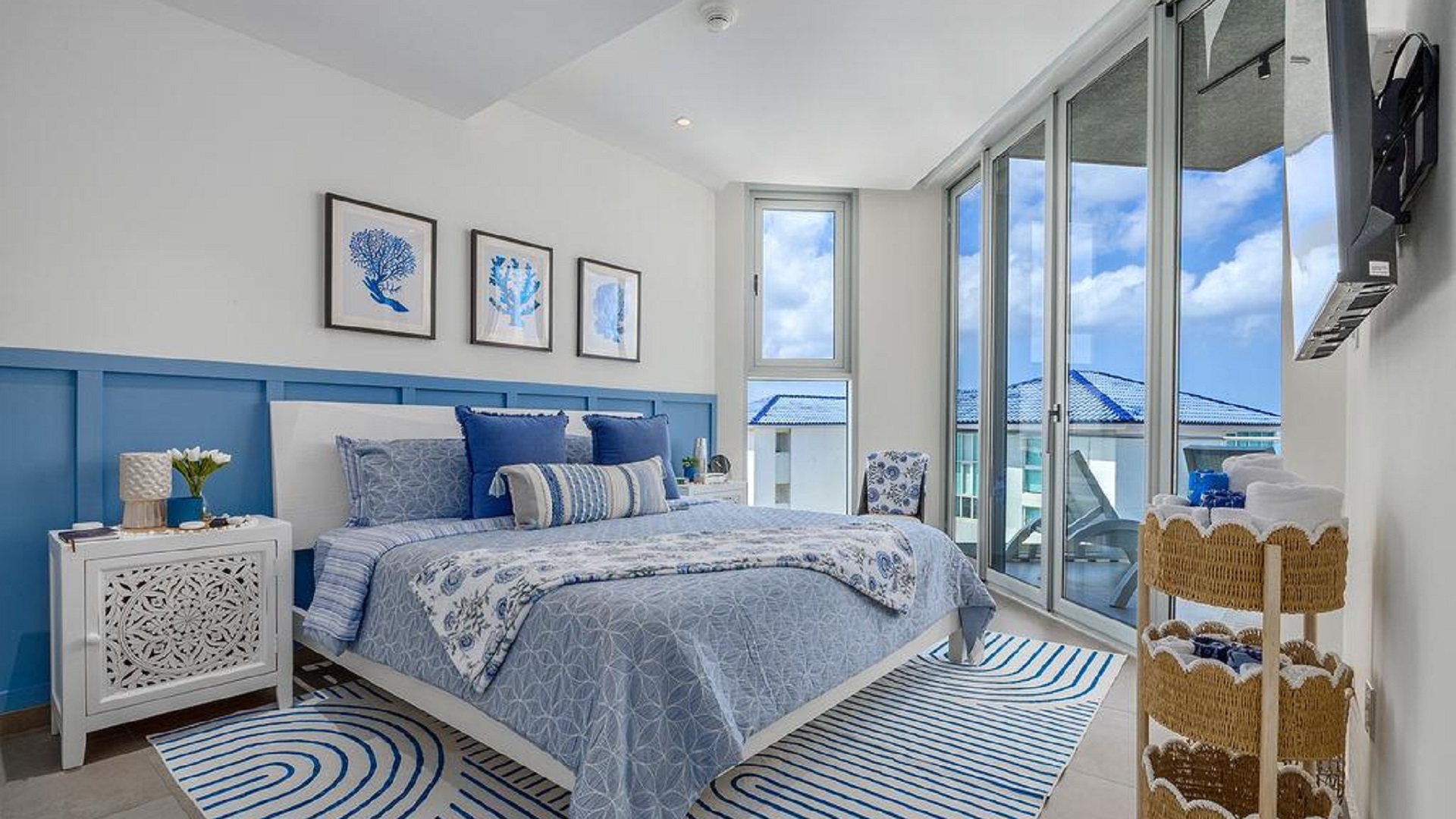 Bedroom in Penthouse PHA at The Reef Residences with balcony access and blue decor in Eagle Beach Aruba