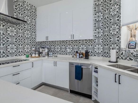 Corner kitchen layout in Reef Residences PHA penthouse with tile backsplash and modern cabinetry in Eagle Beach Aruba