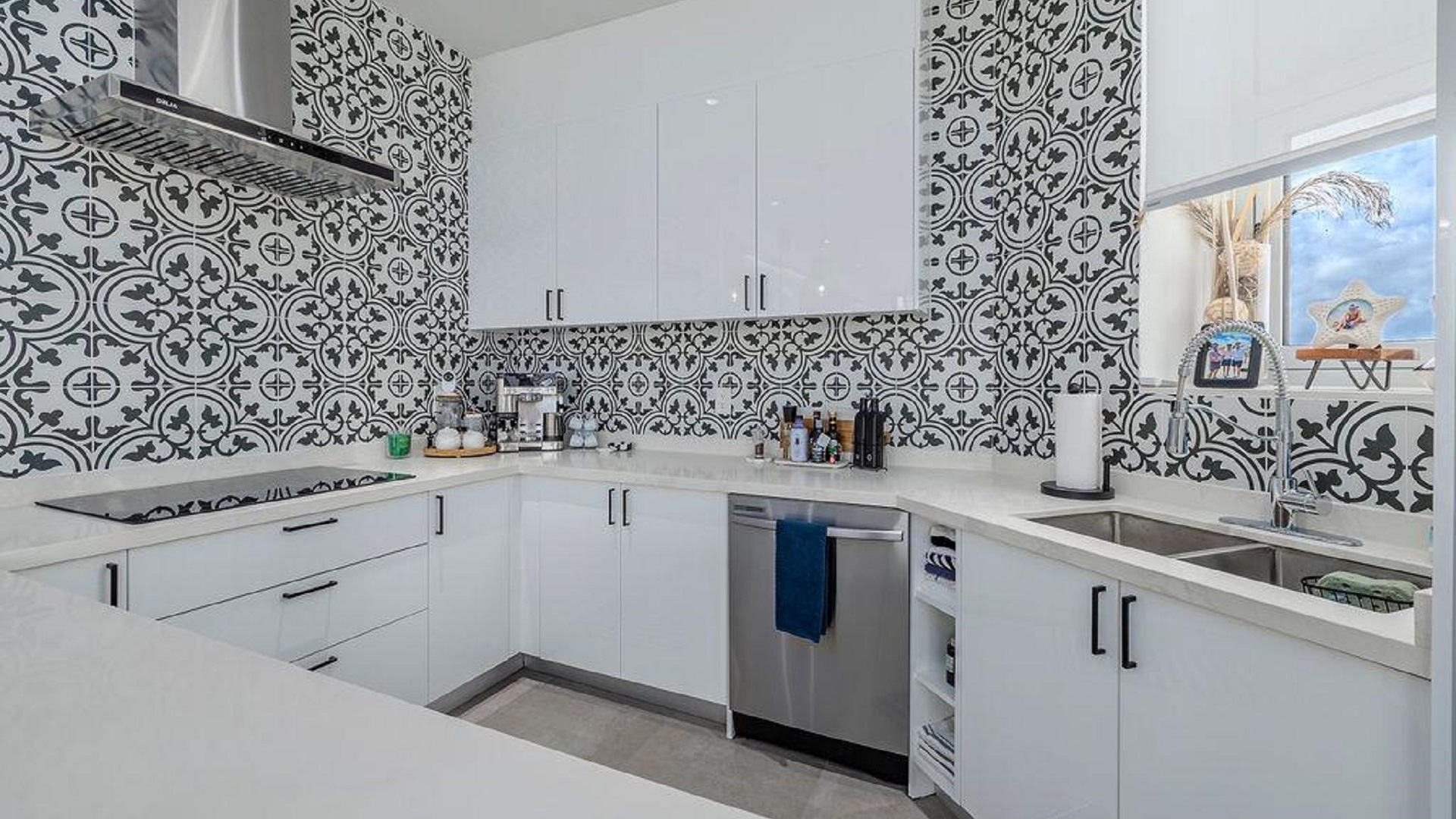 Corner kitchen layout in Reef Residences PHA penthouse with tile backsplash and modern cabinetry in Eagle Beach Aruba