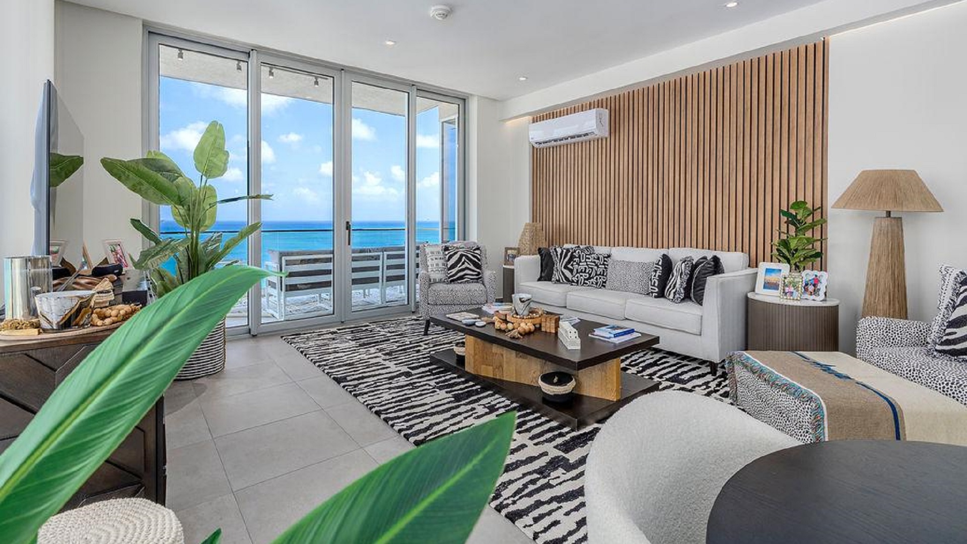 Stylish living room in Reef Residences PHA penthouse facing the ocean with large glass doors in Eagle Beach Aruba