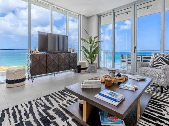 Bright living room in Reef Residences PHA penthouse with wide ocean view windows in Eagle Beach Aruba