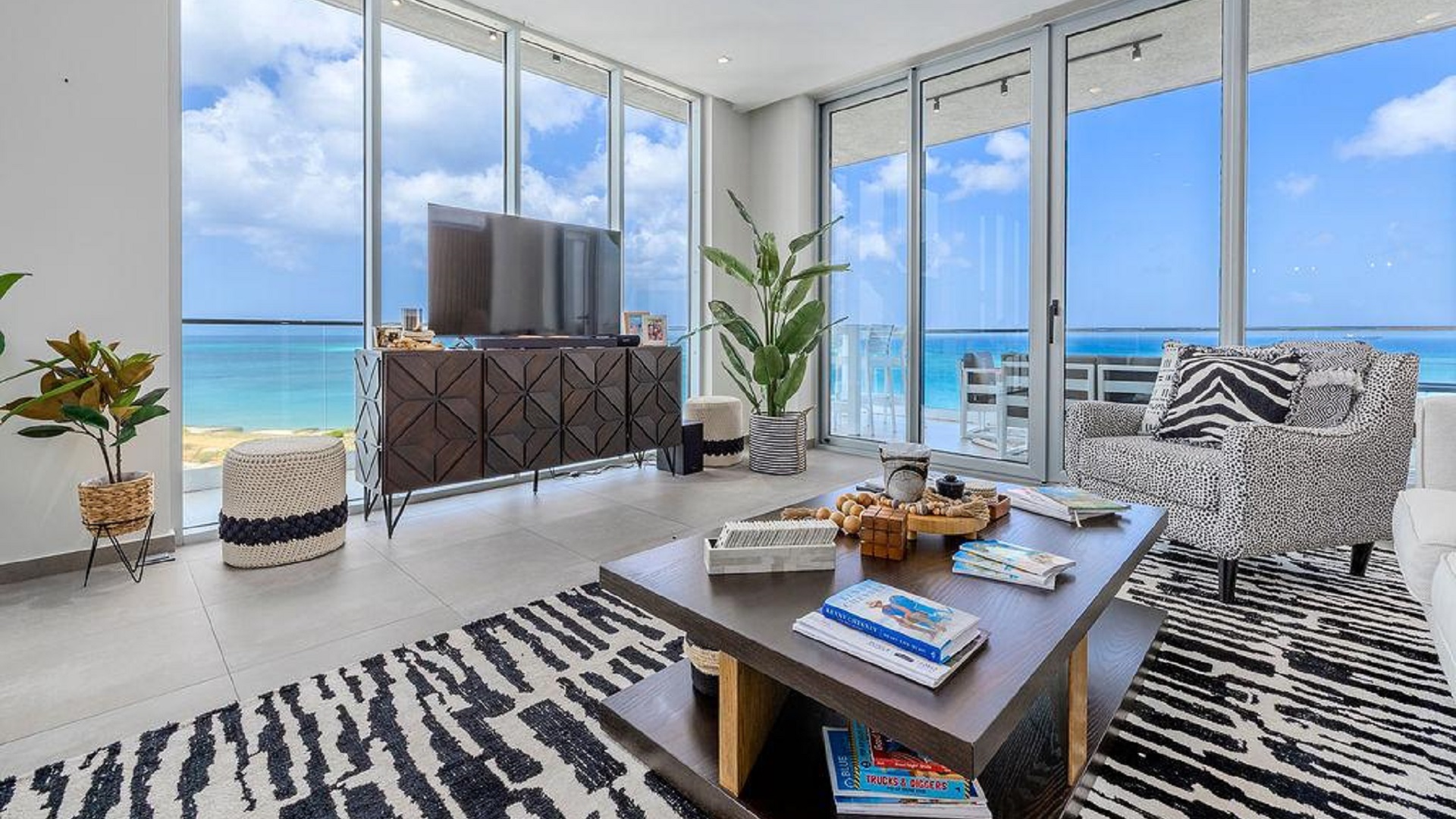 Bright living room in Reef Residences PHA penthouse with wide ocean view windows in Eagle Beach Aruba