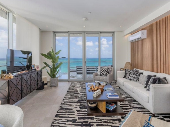 Living room in Reef Residences PHA penthouse with large windows showcasing oceanfront views in Eagle Beach Aruba