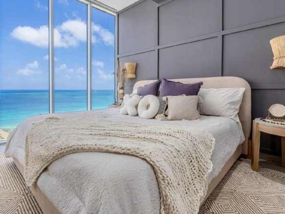 Master bedroom in Reef Residences PHA penthouse with ocean view windows in Eagle Beach Aruba