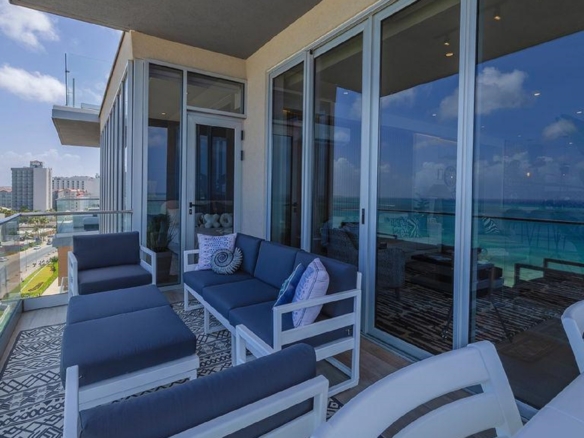 Wraparound balcony of Reef Residences PHA penthouse with seating and partial building view in Eagle Beach Aruba