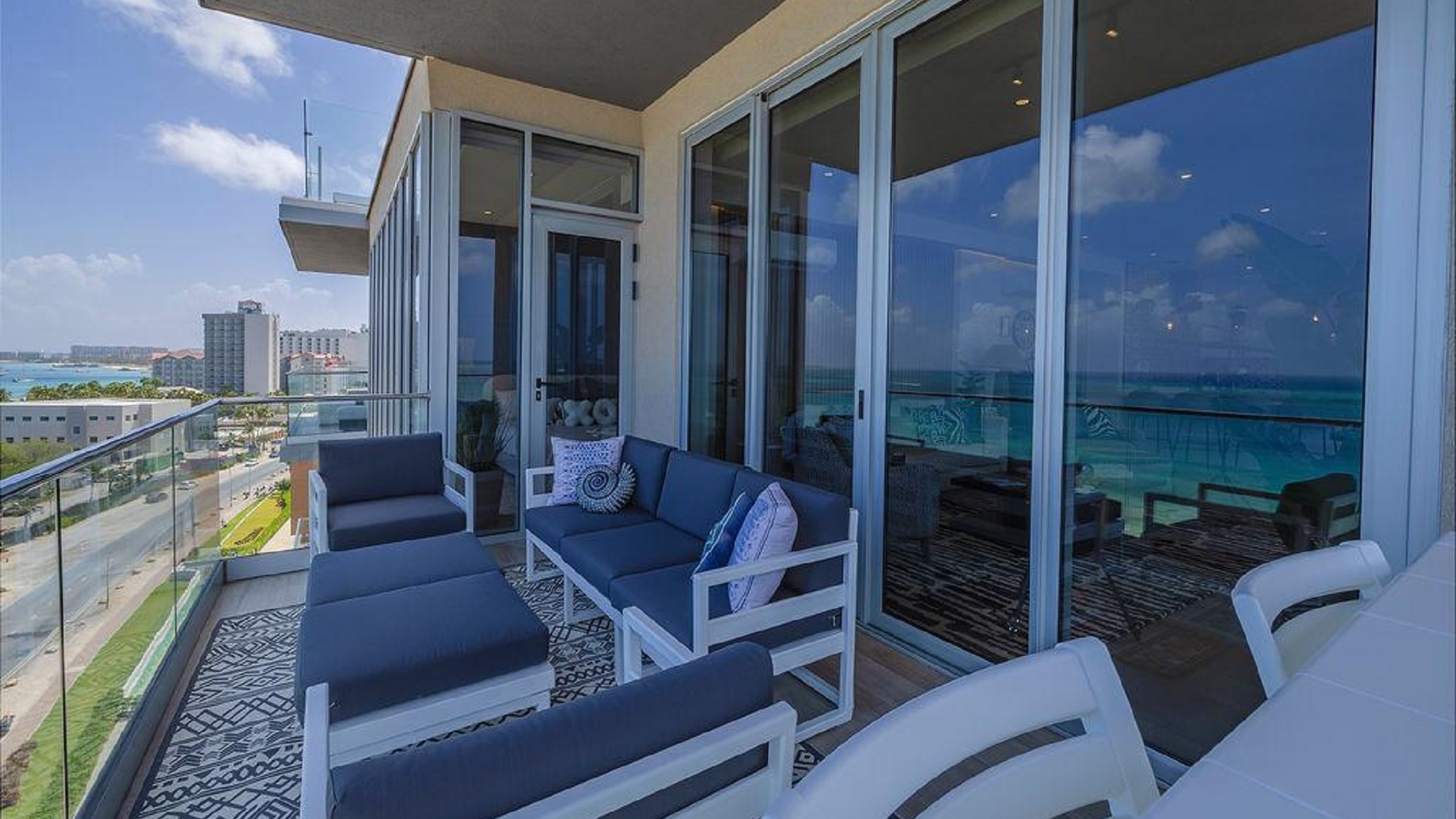 Wraparound balcony of Reef Residences PHA penthouse with seating and partial building view in Eagle Beach Aruba