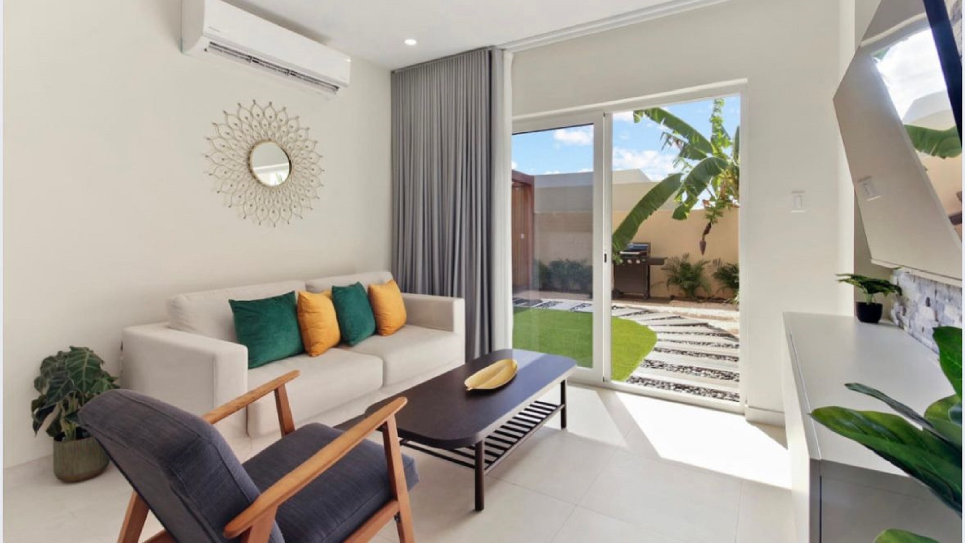 Living room at the 2-Bedroom Oasis at Aracari in Aruba with modern seating, sliding glass doors, and garden view