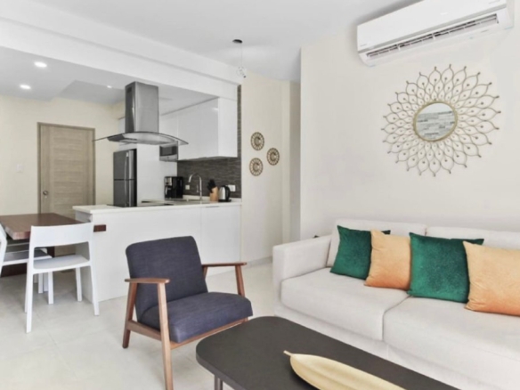 Open-concept living room and kitchen at the 2-Bedroom Oasis at Aracari in Aruba with sofa seating, dining table, and modern kitchen
