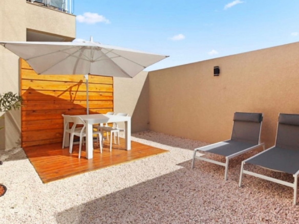 Outdoor lounge space at the 2-Bedroom Oasis at Aracari in Aruba with umbrella-covered dining table and sun loungers