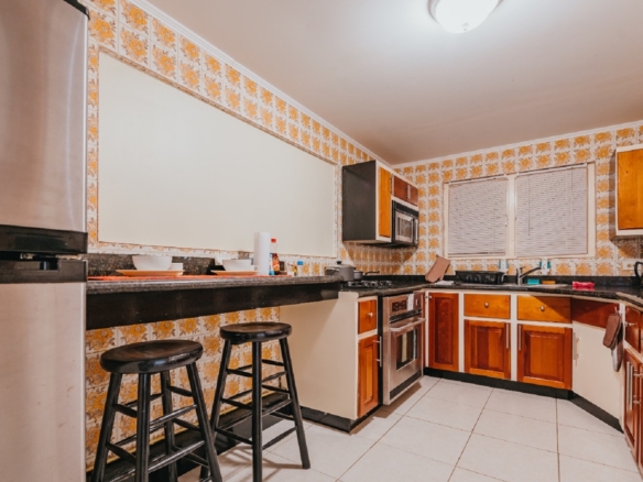 Alternate kitchen view in the 7 studio apartments in Aruba showing wood cabinets, microwav