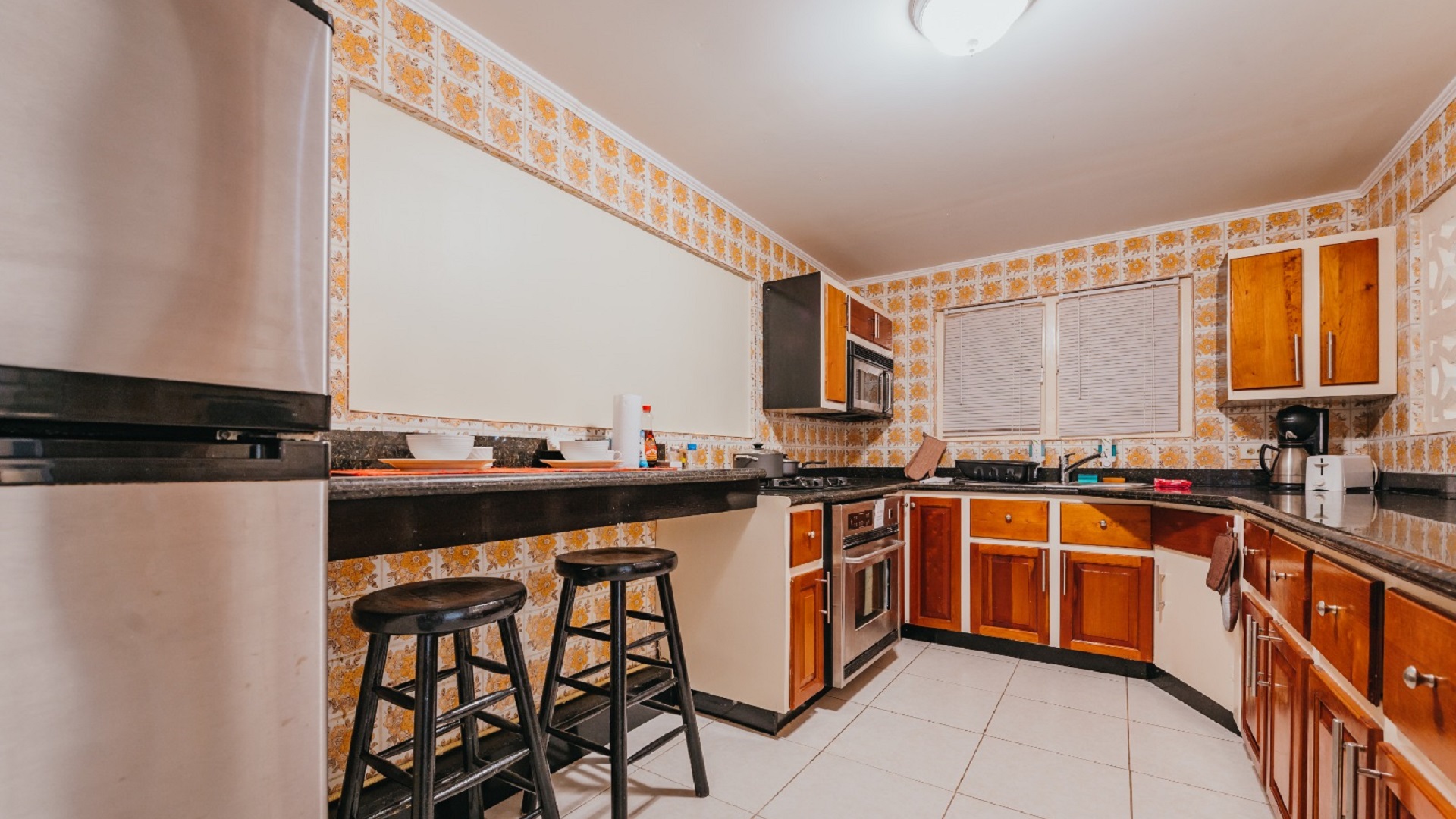 Alternate kitchen view in the 7 studio apartments in Aruba showing wood cabinets, microwav