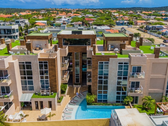 Aerial exterior view of Aracari Phase II condominium building in Aruba with pool and surrounding residences