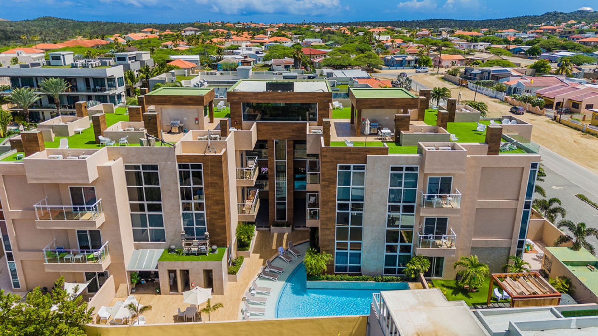 Aerial exterior view of Aracari Phase II condominium building in Aruba with pool and surrounding residences