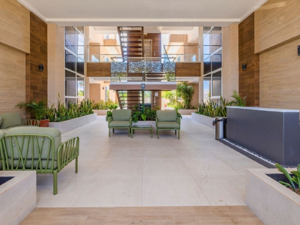 Lobby interior at Aracari Phase II condominium building in Aruba with seating and landscaped decor