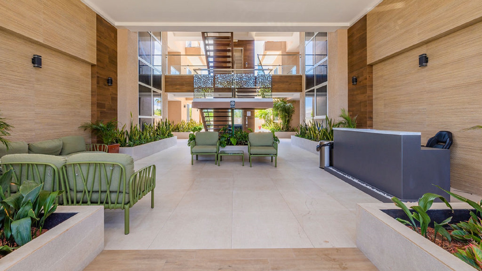 Lobby interior at Aracari Phase II condominium building in Aruba with seating and landscaped decor