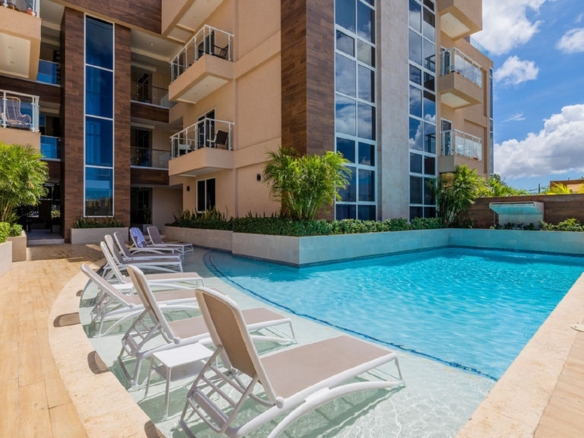 Swimming pool area at Aracari Phase II condominium complex in Aruba with lounge chairs and landscaped surroundings