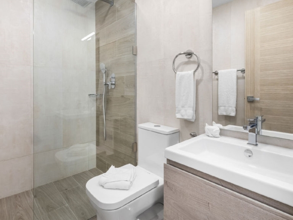 Bathroom with walk-in glass shower and vanity inside Aracari Phase II Unit 13 condo in Aruba