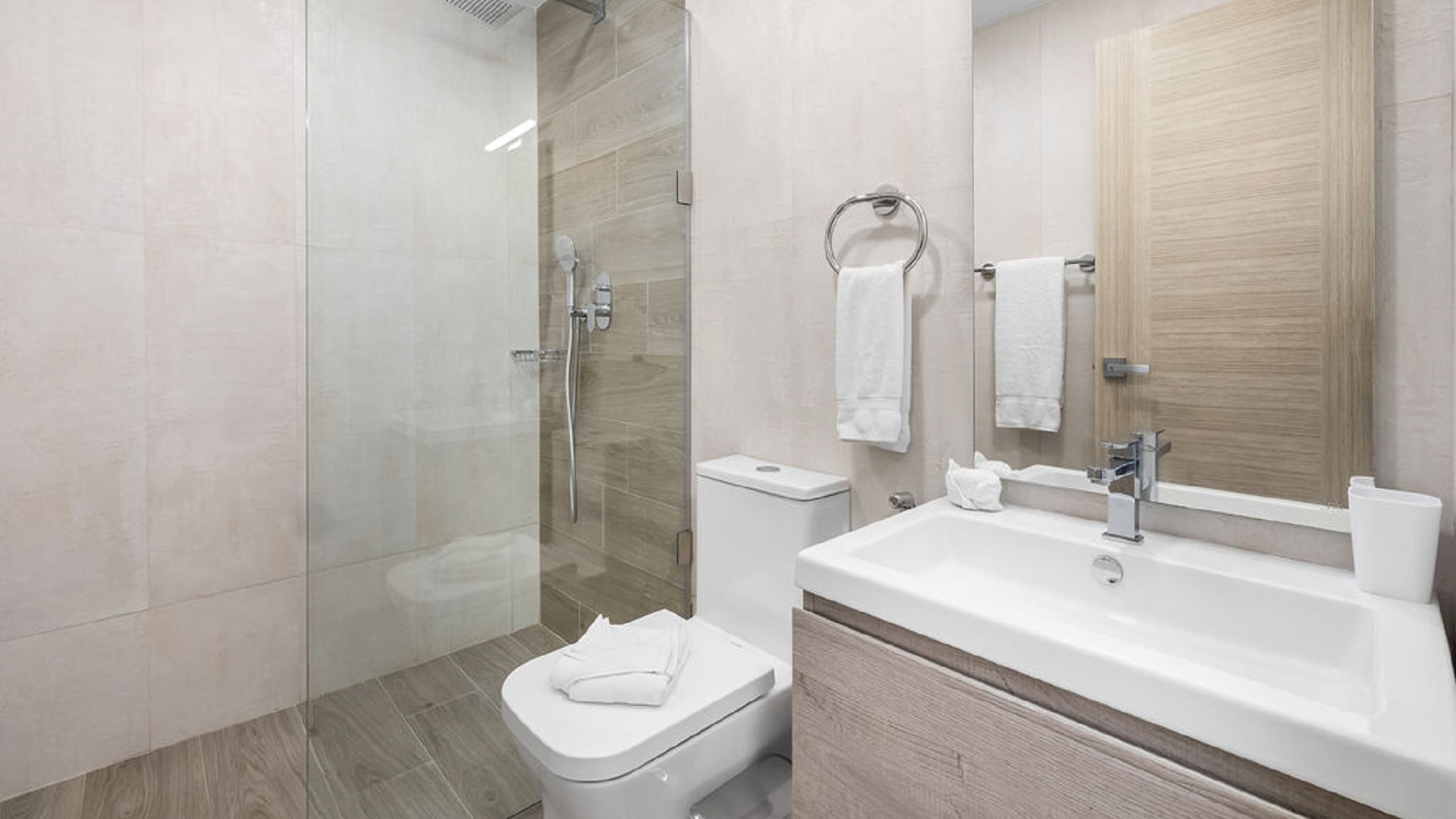 Bathroom with walk-in glass shower and vanity inside Aracari Phase II Unit 13 condo in Aruba