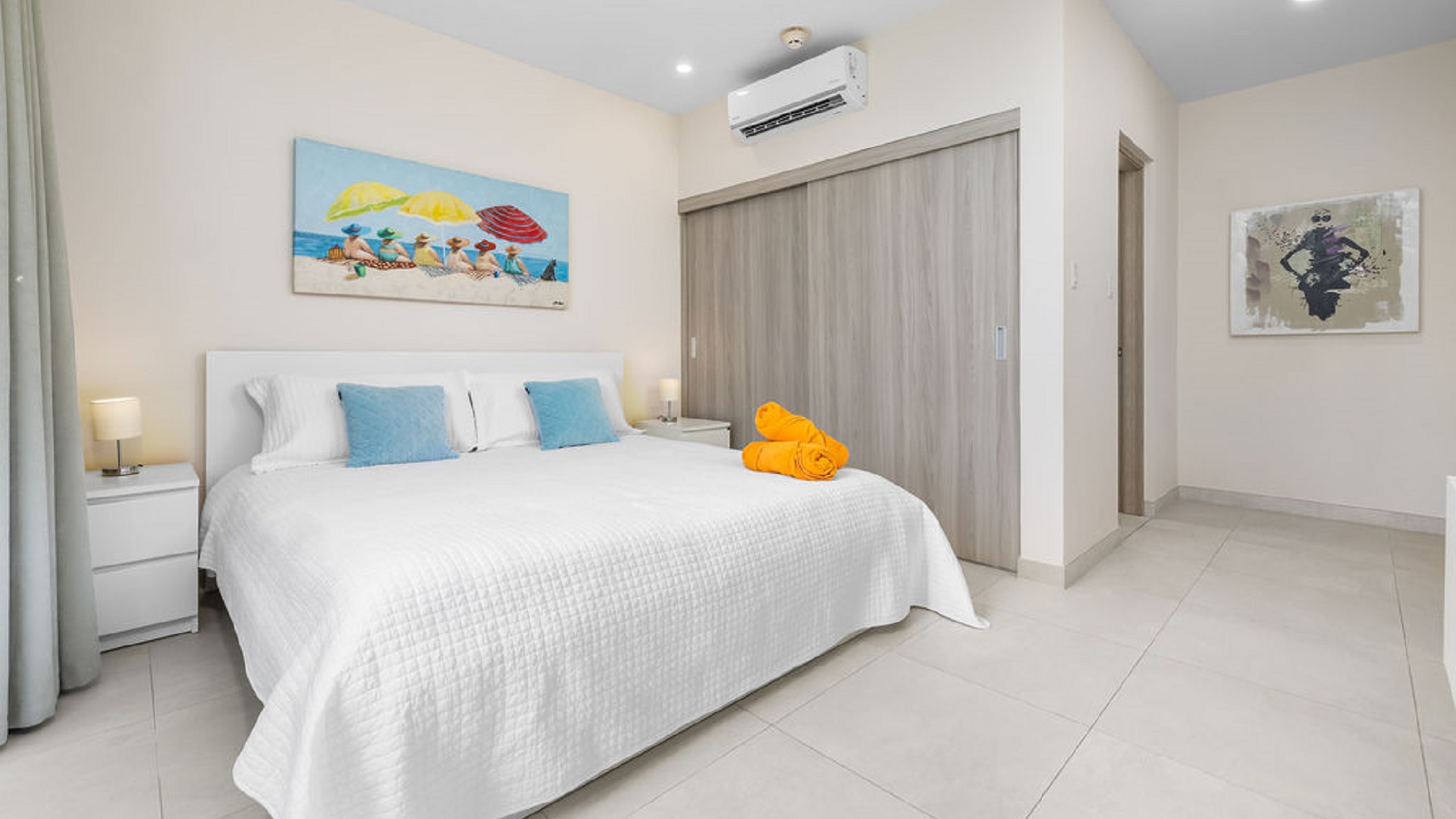 Bedroom interior at Aracari Phase II Unit 13 in Aruba featuring a king bed, artwork, and built-in closet