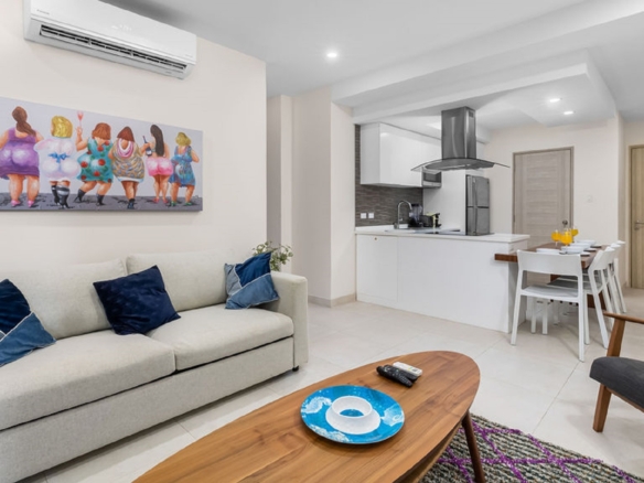 Living room and kitchen area inside Aracari Phase II Unit 13 condo in Aruba with modern furnishings and open layout
