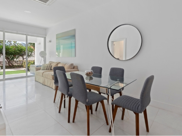 Dining and living area with patio access in Aruba’s Life Garden 2 bedroom condo
