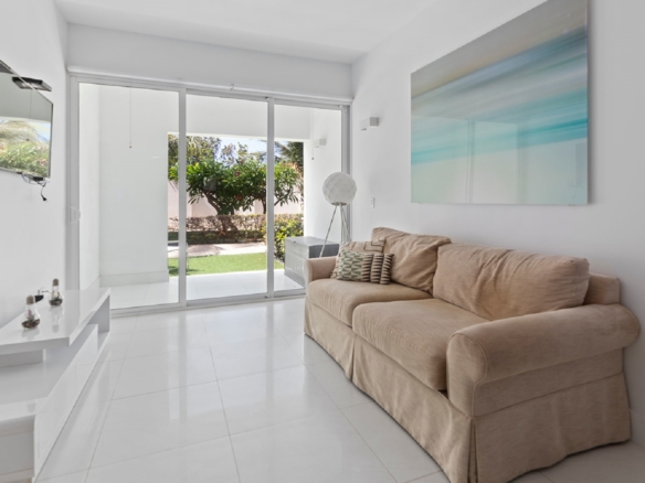 Living room with sliding glass doors and patio view at Aruba’s Life Garden 2 bedroom condo