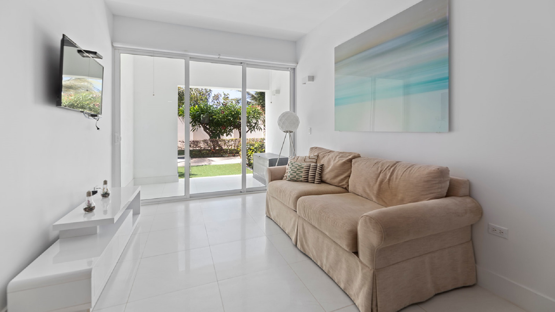 Living room with sliding glass doors and patio view at Aruba’s Life Garden 2 bedroom condo