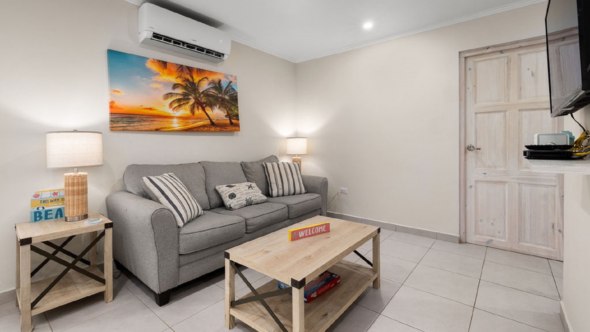 Living room inside the Summerside 2-bedroom condo in Rooi Santo, Aruba with sofa seating and wall-mounted television.