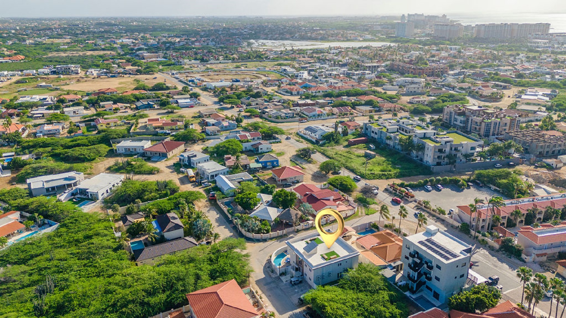 Wide aerial view of the Rooi Santo neighborhood in Aruba featuring the Summerside condo location and nearby residential area.