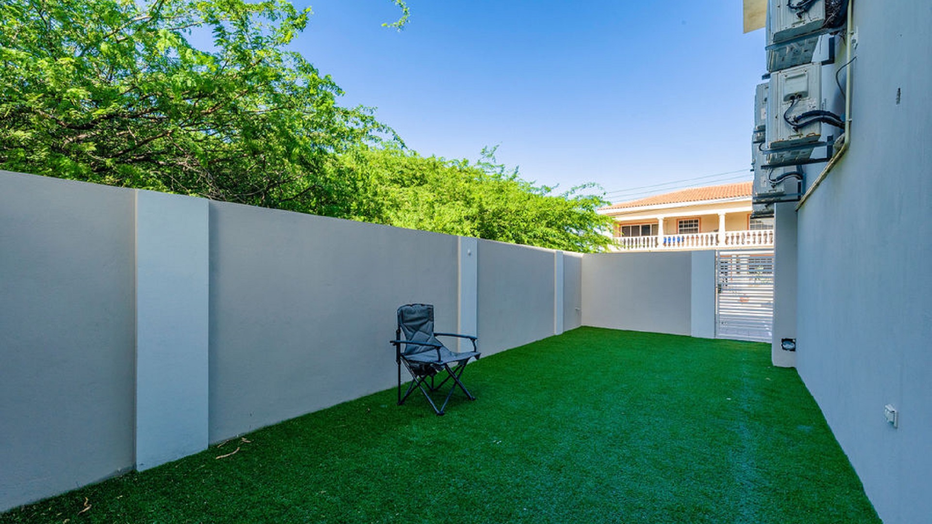 outdoor yard area at the Summerside 2-bedroom condo in Rooi Santo, Aruba with artificial grass and enclosed walls