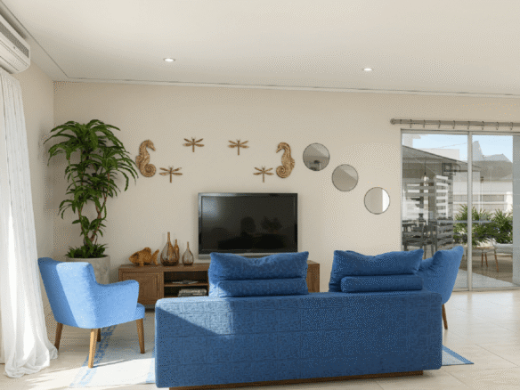 Living room interior at Summerside III townhouse with blue seating, wall décor, and sliding glass doors.