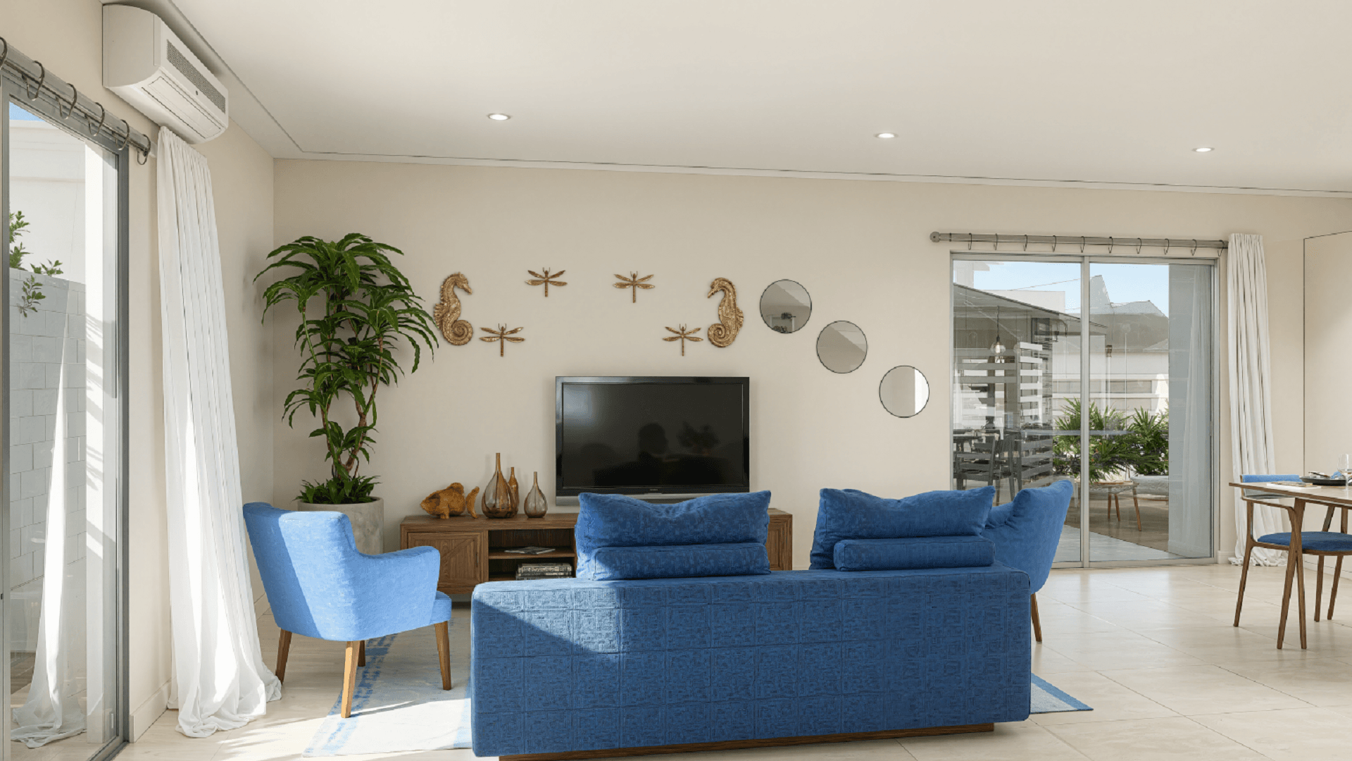 Living room interior at Summerside III townhouse with blue seating, wall décor, and sliding glass doors.